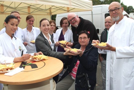 Erika Kempner (77, sitzend) kam im Juni mit einer schweren Lungenentzündung ins St. Josef Krankenhaus in Hilden. Sohn Martin (3.v.r.) bedankte sich jetzt bei den behandelnden Ärzten und dem Pflegepersonal mit Currywurst und Pommes. Darüber freute sich nicht nur Krankenhaus-Direktorin Monika Felkl (4.v.li.). (Foto: B. Glumm)