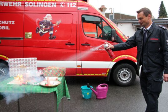 Markus Wehr von der Abteilung vorbeugender Brandschutz der Feuerwehr Solingen demonstrierte, wie man mit einem Löschspray einen brennenden Adventskranz löschen kann. (Foto © Sandra Grünwald)