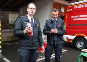 Christian von Egen und Markus Wehr bereiten sich darauf vor, den Adventskranz zu löschen. (Foto © Sandra Grünwald)