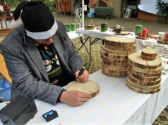 Tierheim-Azubi Leon Werner brennt unermüdlich Tiermotive auf Baumscheiben. Der Adventsmarkt im Tierheim war gut besucht. (Foto: © Martina Hörle)
