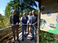 Bürgermeister Thilo Schnoor, Vorsitzender des Behindertenbeirats Horst Koss und Christoph Boddenberg vom LVR (v.l.) weihten unter Aufsicht von Jan Boomers, Leiter der Biologischen Station Mittlere Wupper (im Hintergrund) die neue barrierefreie Aussichtsplattform ein. (Foto © Sandra Grünwald)