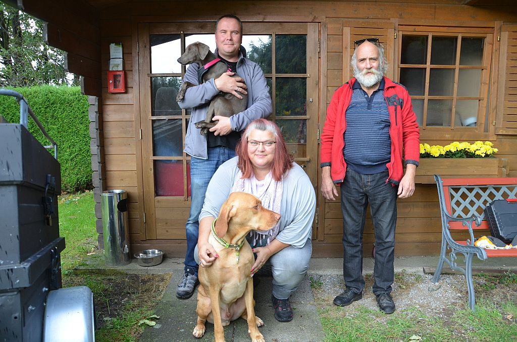 Die neuen Pächter (v. li. Marco und Manuela Struck mit Luna und Eddy) und Mitarbeiter Wolfgang Fleck setzen sich unermüdlich für das Fortbestehen des Tierfriedhofs an der Burger Landstraße ein. Hier finden Tiere an einem beschaulichen Ort ihre letzte Ruhe. (Foto: © Martina Hörle)