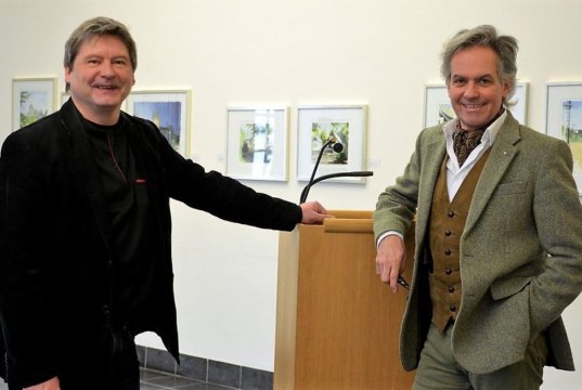 Künstler Andre Peer (li.) ließ am Sonntag im Klingenmuseum zwölf seiner Solinger Ansichten für einen guten Zweck versteigern. Auktionator Dr. Achim Stanneck wusste die Besucher für die Werke zu interessieren und setzte als Anreiz manches Startgebot herunter. (Foto: © Martina Hörle)