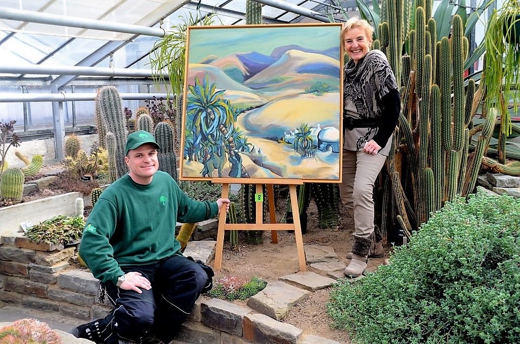 Derzeit können Besucher in den Gewächshäusern im Botanischen Garten 32 Bilder der Künstlerin Petra Ostermann besichtigen. Die Werke haben sich wunderbar in die Pflanzenwelt eingefügt. Matthias Nitsche, stv. Vorsitzender der Stiftung Bot. Garten, ist von der Ausstellung sehr angetan. (Foto: © Martina Hörle)