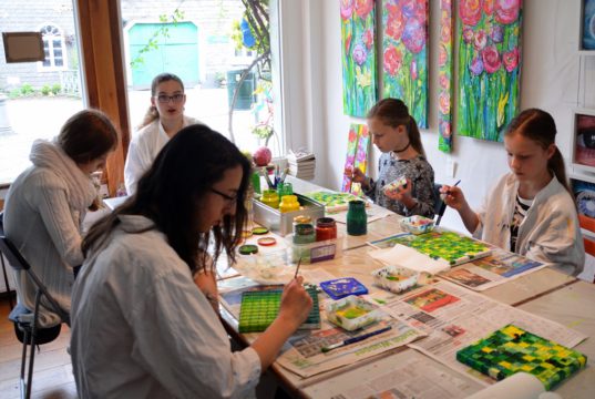 Die fünf jungen Malerinnen im Alter von 10 – 14 Jahren sitzen mit großer Begeisterung an ihrer Arbeit. Alle sind stolz darauf, an diesem großen Gemeinschaftswerk mitzuarbeiten. (Foto: © Martina Hörle)