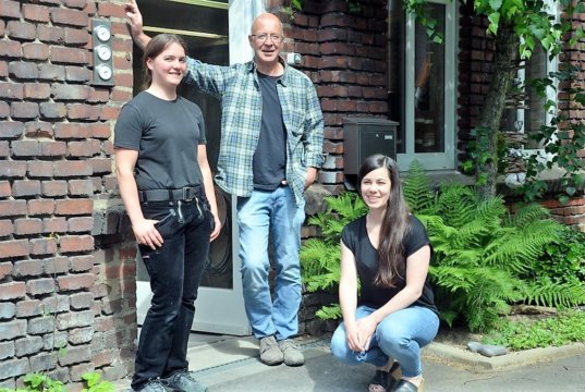 Künstler und Handwerker laden gemeinsam zum Tag der offenen Tür. Tischlermeister Thomas Gerhards (hier mit seiner Auszubildenden Ruby Daun, li.) wird die Gäste durch seine Werkstatt führen. Buchbinderin Clara Schmidt weiß von den alten Maschinen und deren Einsatz zu berichten. (Foto: © Martina Hörle)