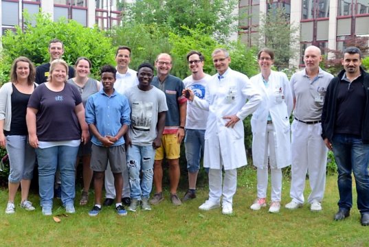 (v. li. Laura Grass, Ulla Rappen, Silas Robke, Anna Robke, Percy Rappen von VIZAZI, Dr. Oliver Voß, Steven Jacob Amunga, Dieter Rappen, Michele Lorenzo Patricelli, Prof. Dr. Sascha Flohé, Dr. Ellen Abendroth, Oberarzt Eberhardt Heindl, Dr. Amer Aldahouk) Alle Beteiligten – Ärzte und Organisatoren – trafen sich heute in der Cafeteria des Klinikums, um sich von Steven Jacob Amunga zu verabschieden. Der junge Mann fliegt Mitte Juni nach seiner erfolgreich verlaufenden Operation zurück nach Kenia. (Foto: © Martina Hörle)