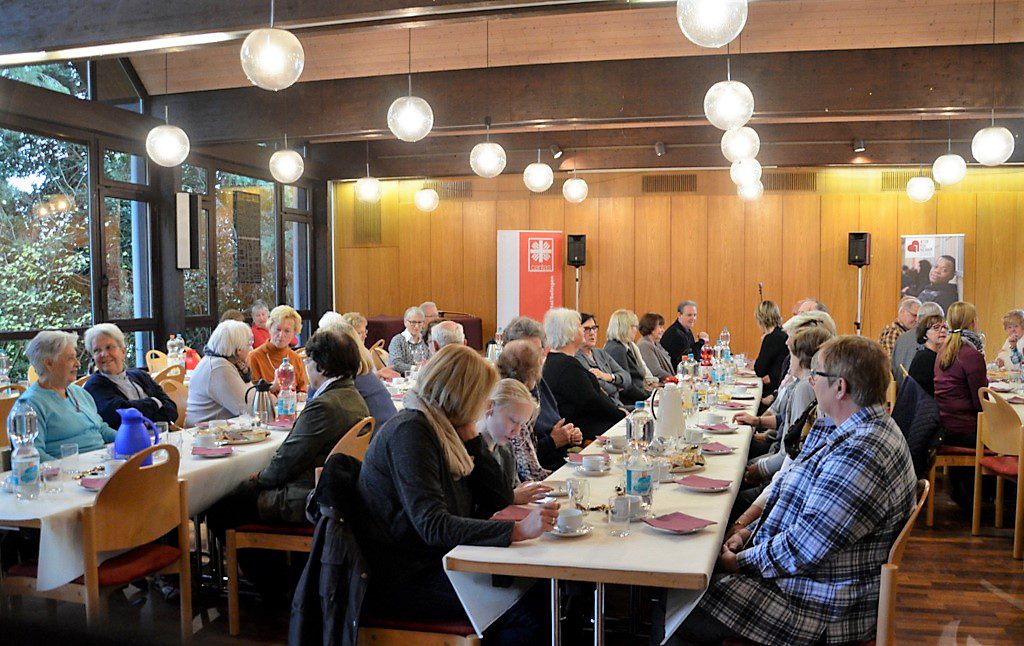 Rund 65 ehrenamtliche Helfer sind der Einladung der Caritas gefolgt. In munteren Gesprächen bei Kaffee und Kuchen tauschen sie sich aus und warten voll Spannung auf das angekündigte Programm. (Foto: © Martina Hörle)