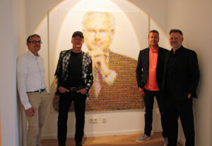 Tim Heinekamp, Thomas Baumgärtel, Torsten Zielke und Künstler Dirk Balke (v.l.), der die Parteien zusammenbrachte, vor dem Stielbild von Harald Schmidt. (Foto © Sandra Grünwald)