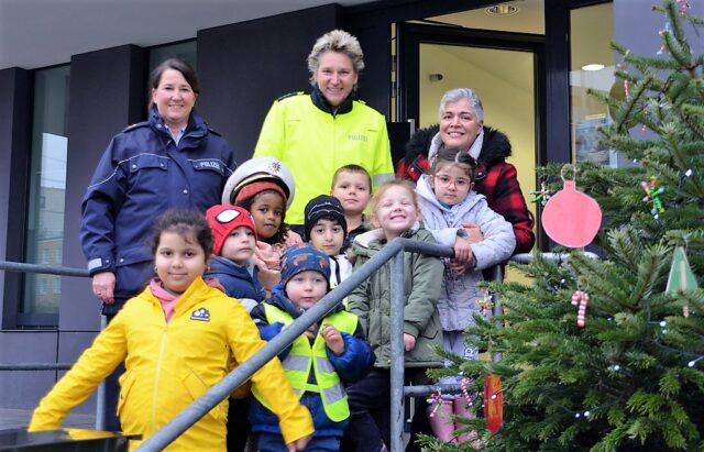 Claudia Schepanski, Katrin Grastat und Bea Bianco (v. li.) freuen sich gemeinsam mit den Kindern der Kita Löwenzahn über das Schmücken des Weihnachtsbaumes. (Foto: © Martina Hörle)