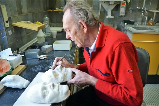 Für Paul Stöber, Firmengründer von „KÖRPER & FORM“, ist die Herstellung von Gesichtsmasken und Erinnerungsschmuck eine Berufung. Hier arbeitet er ganz präzise an einer Maske die Augenbrauen nach. (Foto: © Martina Hörle)