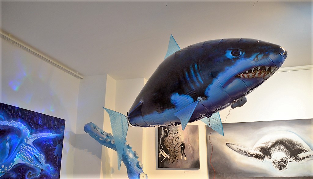 Ein großer Hai hängt unter der Decke. Diese fliegende Figur aus Pappmaché ist eines der Hai-Lights der Ausstellung. (Foto: © Martina Hörle)