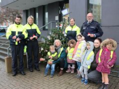 Einige Kinder des städtischen Familienzentrums Schatzkiste waren gekommen, um den Weihnachtsbaum vor der Polizeiinspektion zu schmücken – sehr zur Freude der Polizistinnen und Polizisten. (Foto © Sandra Grünwald)