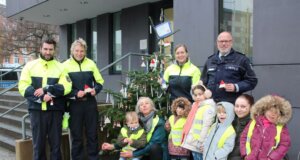 Einige Kinder des städtischen Familienzentrums Schatzkiste waren gekommen, um den Weihnachtsbaum vor der Polizeiinspektion zu schmücken – sehr zur Freude der Polizistinnen und Polizisten. (Foto © Sandra Grünwald)