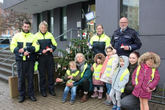 Einige Kinder des städtischen Familienzentrums Schatzkiste waren gekommen, um den Weihnachtsbaum vor der Polizeiinspektion zu schmücken – sehr zur Freude der Polizistinnen und Polizisten. (Foto © Sandra Grünwald)