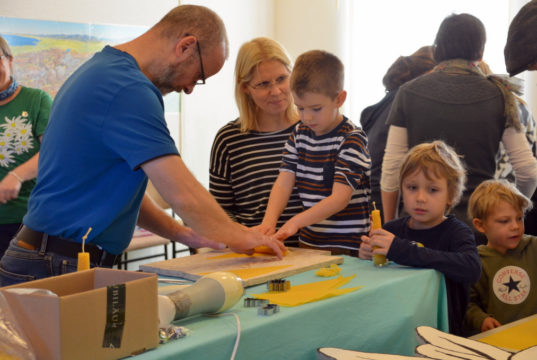 Im Vereinsheim des Deutschen Alpenvereins Sektion Solingen fand am Samstag ein reges Treiben statt. Vereinsmitglied Stefan Sahler (vorne) formte mit den Kindern echte Bienenwachskerzen. (Foto: © Martina Hörle)