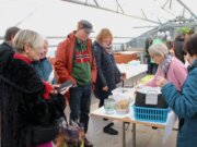 Ehrenamtlerin Verena Kara-Jahn (links) informierte die tauschfreudigen Besucher der Saatgutbörse über die Sämereien und vorgezogene Pflanzen. (Foto © Sarah Schmitz)
