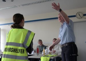 Polizeihauptkommissarin Daniela Berghaus mimt beim Rollenspiel ältere Schüler, die neben der Lotsin über die Straße gehen wollen. (Foto © Sandra Grünwald)