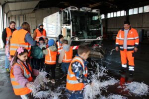 Ferdi, Fahrer der Kehrmaschine (rechts) ließ die Kinder Papierschnipsel verteilen. (Foto © Sandra Grünwald)