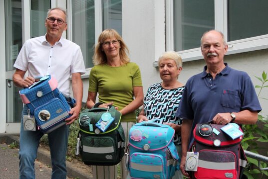 Joachim Blümer, Präsident des Kiwanis Clubs und seine Frau mit Brigitte Funk, Vorsitzende der Solinger Tafel und Stefan Schreiner, Sekretär des Kiwanis Clubs, (v.l.) freuen sich über die Tornister für die Solinger I-Dötzchen. (Foto © Sandra Grünwald)