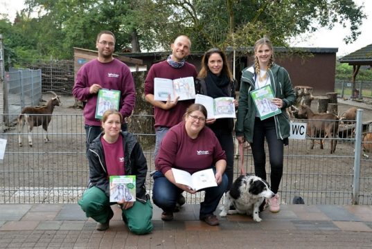 Janett Heinrich (vorne re.), ltd. Tierpflegerin, und ihr Team freuen sich gemeinsam mit Kirsten Schmitz (hinten, 2. v. re.) und Carolin Heibges (hinten rechts) über das neue Kinderbuch und den Kalender. Ab dem 1. Oktober ist beides im Tierpark erhältlich. (Foto. © Martina Hörle)