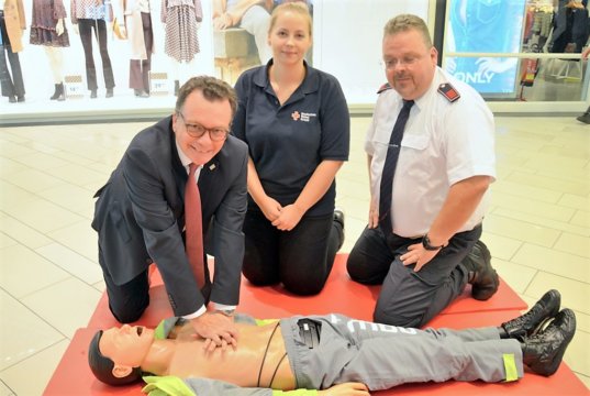 Prof. Dr. Thomas Standl, Sabrina Wlasak, DRK, und Oliver Koch von der Berufsfeuerwehr demonstrieren die Herz-Druck-Massage. (Foto: © Martina Hörle)