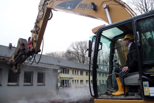 Den ersten "Biss" liess sich Oberbürgermeister Tim Kurzbach am Mittwochmorgen nicht nehmen. Er knabberte am Steuer eines Baggers den Altbau höchstpersönlich an. (Foto: © Bastian Glumm)