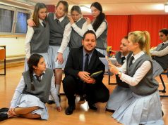 Hier wird eine Szene im Klassenzimmer geprobt. Die Schülerinnen hören gespannt zu, als der Lehrer, gespielt von Matthias Dudda, einem ehemaligen Schüler, von früher erzählt. Die Proben zu dem Stück bedeuten für die Musiktheater-Mitglieder etwa zwei Jahre harte Arbeit. (Foto: © Martina Hörle)