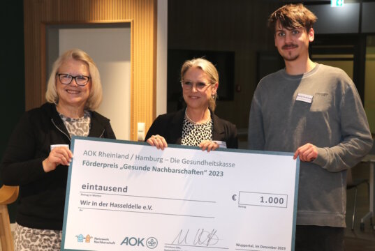 Christiane Otto (mi.), AOK-Regionaldirektorin Bergisches Land, überreichte jetzt den Scheck in Höhe von 1.000 Euro an Andrea Johanna Ditgens und Malte Andresen vom Verein „Wir in der Hasseldelle“. (Foto: © Bastian Glumm)