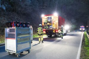 Feuerwehrkräfte richten am Balkhauser Weg die Einsatzstelle ein und sorgen während der Räumarbeiten nach dem Felssturz für Ausleuchtung und Absicherung der Straße. (Foto: © Tim Oelbermann)