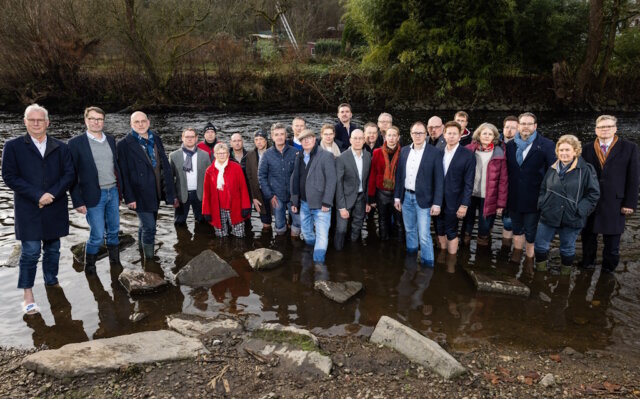 Über 20 Unternehmerinnen und Unternehmer aus dem Bergischen Städtedreieck stehen symbolisch in der Wupper, um auf die angespannte wirtschaftliche Lage der Industrie und den aus ihrer Sicht wachsenden Handlungsdruck für Politik und Verwaltung aufmerksam zu machen. (Foto: © Malte Reiter / Bergische IHK)