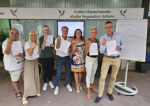 Strahlende Gesichter nach einem vergangenen Slang-Workshop: Sabrina Vitale (mi.) mit Teilnehmern des italienischen Slang-Kurses – alle erhielten ein Zertifikat für ihre Teilnahme. (Foto: © Colibri Bildung)