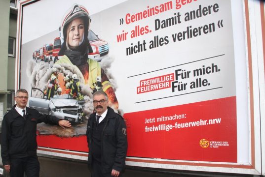 Landesweit wird großflächig um Nachwuchs für die Einheiten der Freiwilligen Feuerwehr geworben. Torsten Dunkel (li.) und Hans-Joachim Krapp von der Solinger Feuerwehr stellten die Kampagne am Plakatstandort in Aufderhöhe vor. (Foto: © B. Glumm)