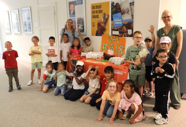 grundschule-augustastrasse-fairer-handel-rathaus (1) Die Klasse 1a der Grundschule Augustastraße präsentierte im Solinger Rathaus ihre selbstgemachten Schokocrossies und informierte über fairen Handel. Klassenlehrerin Sabine Buchmüller (r.) begleitete das Projekt. (Foto: © Bastian Glumm)