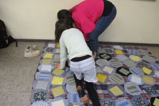 Aus Jeans wird Kunst: Schülerinnen und Schüler der 5b legen konzentriert die farbigen Quadrate aus, bevor der Quilt zusammengenäht wird. (Foto: © Gesamtschule Höhscheid)