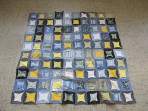 Fast geschafft: Die zusammengenähte Patchworkdecke zeigt bereits das typische Domfenster-Muster des fertigen Quilts. (Foto: © Gesamtschule Höhscheid)