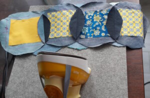 Ausgeschnittene Jeanskreise und bunte Stoffquadrate: So beginnt jedes einzelne Element des späteren Cathedral-Window-Quilts. (Foto: © Gesamtschule Höhscheid)