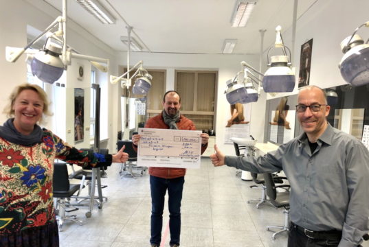 Kreishandwerksmeister Arnd Krüger (mi.) überreicht den Scheck über den Unterstützungsbetrag an die Obermeisterin der Friseur-Innung, Pia Schneider, und den stellv. Obermeister Andreas Schick. (Foto: © Kreishandwerkerschaft Solingen-Wuppertal)