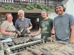 Die Winzerfamilie Lingen vor zwei Gitterboxen mit verschlammten Weinflaschen. Von links: Tanja, Peter, Niklas und Jan Lingen. (Foto: © Familie Lingen)