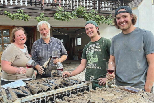 Die Winzerfamilie Lingen vor zwei Gitterboxen mit verschlammten Weinflaschen. Von links: Tanja, Peter, Niklas und Jan Lingen. (Foto: © Familie Lingen)