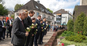 Ein Jahr nach dem Anschlag: Oberbürgermeister Tim Kurzbach, Ministerpräsident Hendrik Wüst und weitere Gäste gedachten am Freitag der Opfer und legten weiße Rosen an der Gedenktafel an der Stadtkirche nieder. (Foto: © Stadt Solingen)
