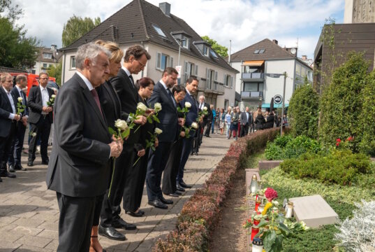 Ein Jahr nach dem Anschlag: Oberbürgermeister Tim Kurzbach, Ministerpräsident Hendrik Wüst und weitere Gäste gedachten am Freitag der Opfer und legten weiße Rosen an der Gedenktafel an der Stadtkirche nieder. (Foto: © Stadt Solingen)