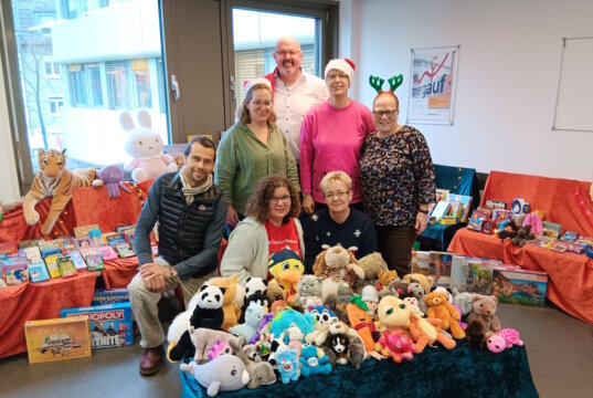 Sorgten für leuchtende Kinderuagen zu Weihnachten: Vorne v.l. knieend Sascha von Schwedler (Toys Company Wuppertal), Sylwia Wirkus und Sabine Boddenberg vom KundenServiceCenter des kommunalen Jobcenters, dahinterstehend v.l.: Julia Heitmann und Martina Chudek von den TBS, Stefanie Mergehenn (Beauftragte für Chancengleichheit am Arbeitsmarkt und Öffentlichkeitsarbeit des kommunalen Jobcenters), ganz hinten: Mike Häusgen, Leiter des kommunalen Jobcenters Solingen- (Foto: © Jürgen Klug)