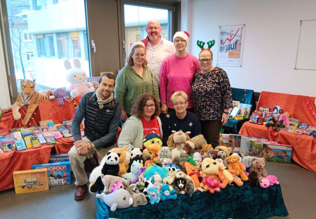 Sorgten für leuchtende Kinderuagen zu Weihnachten: Vorne v.l. knieend Sascha von Schwedler (Toys Company Wuppertal), Sylwia Wirkus und Sabine Boddenberg vom KundenServiceCenter des kommunalen Jobcenters, dahinterstehend v.l.: Julia Heitmann und Martina Chudek von den TBS, Stefanie Mergehenn (Beauftragte für Chancengleichheit am Arbeitsmarkt und Öffentlichkeitsarbeit des kommunalen Jobcenters), ganz hinten: Mike Häusgen, Leiter des kommunalen Jobcenters Solingen- (Foto: © Jürgen Klug)