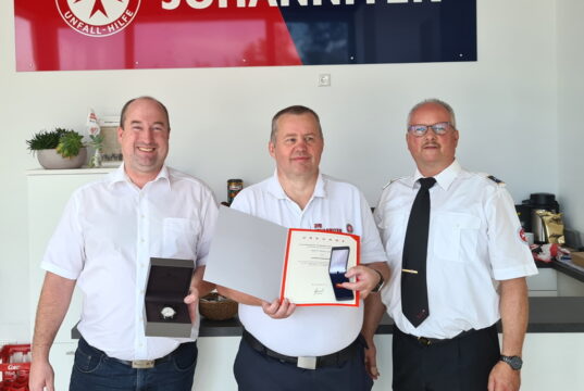 JUH-Regionalvorstand Stefan Müller (li.) und Ortsbeauftragter Peter Schumacher (re.) sind stolz auf ihren langjährigen ehrenamtlichen Helfer Heiko Vietz. (Foto: © Johanniter-Unfall-Hilfe e.V./ Aristidis Fotiadis)