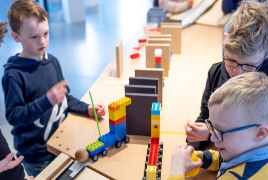 Kinder tüfteln im Industriemuseum Gesenkschmiede Hendrichs an einer Kettenreaktion. Beim Kinderfest „Probiert? Kapiert!“ steht gemeinsames Experimentieren im Mittelpunkt. (Foto: © Stefan Arendt)