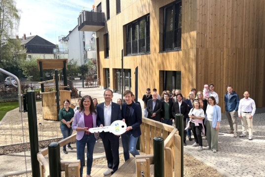 Vertreterinnen und Vertreter von Stadt und SEG übergeben symbolisch den Schlüssel für die neue Kita „Wichtelwald“ an der Schwanenstraße und eröffnen damit offiziell das Gebäude mit Kita und geförderten Wohnungen. (Foto: © Stadtentwicklungsgesellschaft Solingen)