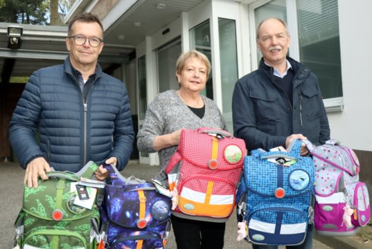 Brigitte Funk von der Solinger Tafel freute sich über 35 brandneue Schultornister, die am Samstag Martin Idelberger (li.) und Stefan Schreiner vom KIWANIS Club Solingen vorbeibrachten. (Foto: © Bastian Glumm)