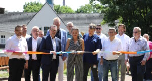 SPZ-Psychologin Sandra Kratz ist die treibende Kraft für den neuen Spielplatz am Klinikum, sie griff zur Schere und durchschnitt das Band zur Eröffnung. An ihrer Seite: Die Geschäftsleitung des Klinikums und ganz viele Unterstützer. (Foto: © Bastian Glumm)