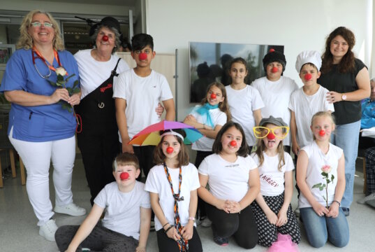Chefärztin Nicole Backes (li.), Anne Blessmann (2.v.l.) und Schulleiterin Margarete Gorol (re.) mit den Kindern der Clown-AG der Grundschule Scheidter Straße nach ihrem Auftritt auf Station B21 im Klinikum Solingen. (Foto: © Bastian Glumm)